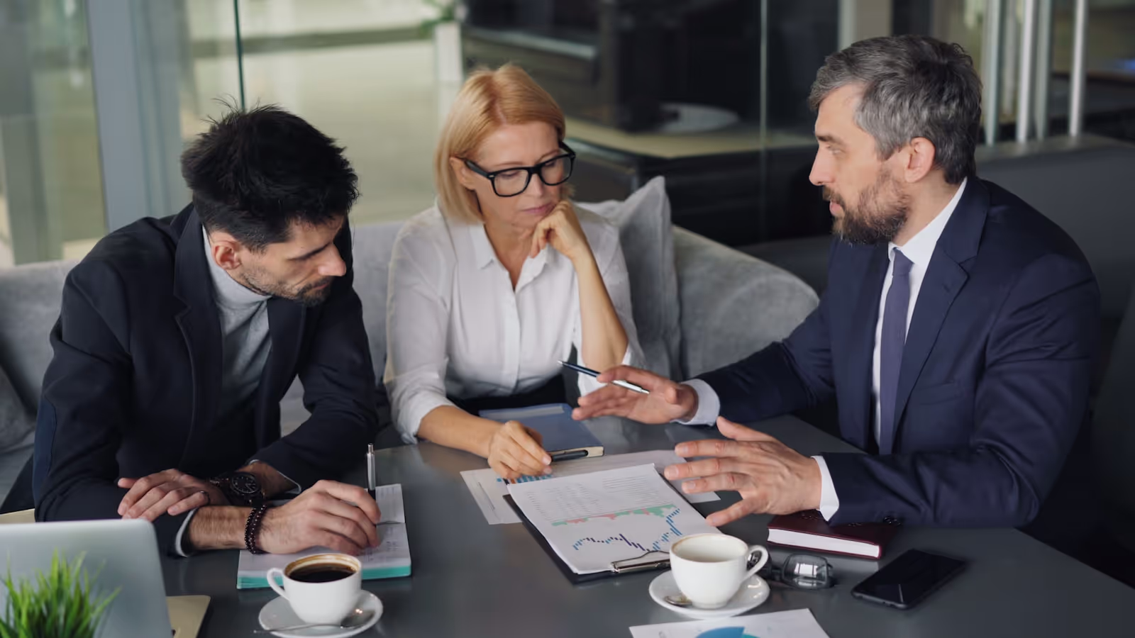 Executives reviewing strategic resources and documents in a modern office.