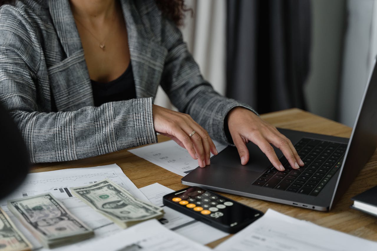Amazon PPC Agency Red Flags — Protect Your Profit A woman reviewing her Amazon business performance on a laptop, visually identifying Amazon PPC agency red flags to protect her profit and ad spend.