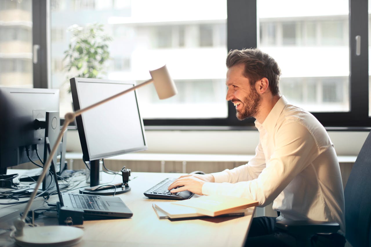 Long Tail Keywords Strategy Boosting Amazon Sales Results A man smiling happily while checking increased Amazon sales on his computer after using a long tail keywords strategy to improve SEO and performance