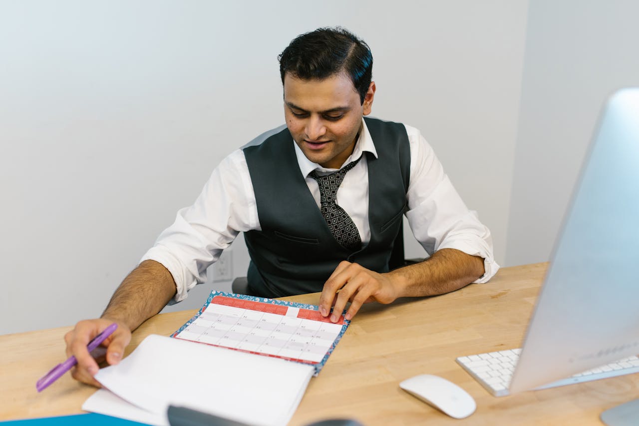Scheduling the Next Amazon PPC Audit Businessman checking a calendar to schedule his next Amazon PPC audit and plan advertising optimization.