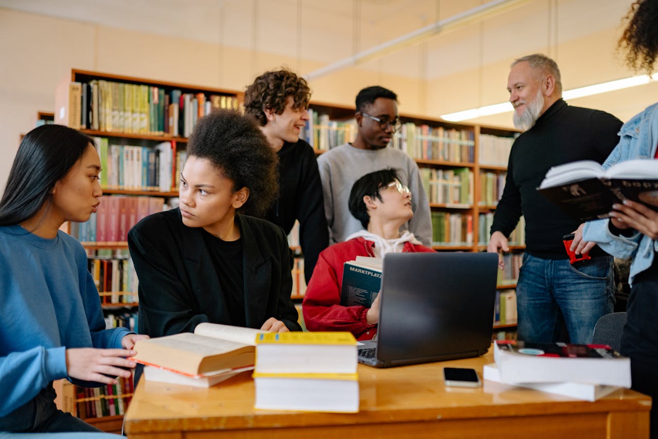 Evaluating College Student Financial Wellness Outcomes A professor talking to a group of college students, discussing key metrics like retention, graduation rates, and service utilization to measure the effectiveness of college student financial wellness