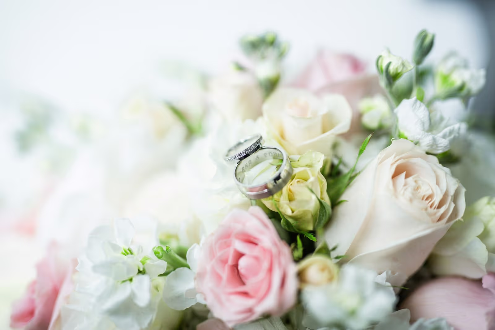 Close-up of wedding rings placed on a floral bouquet