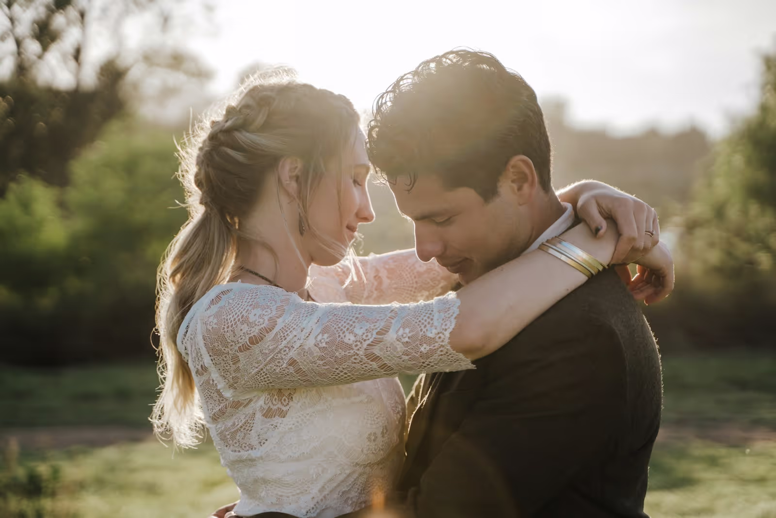 A romantic wedding couple embracing outdoors