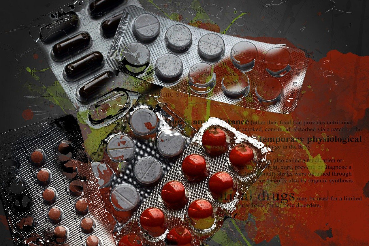 Overlapping blister packs of various tablets and capsules—red, brown, and gray—on a dark grunge background with paint splashes and faint medical text.