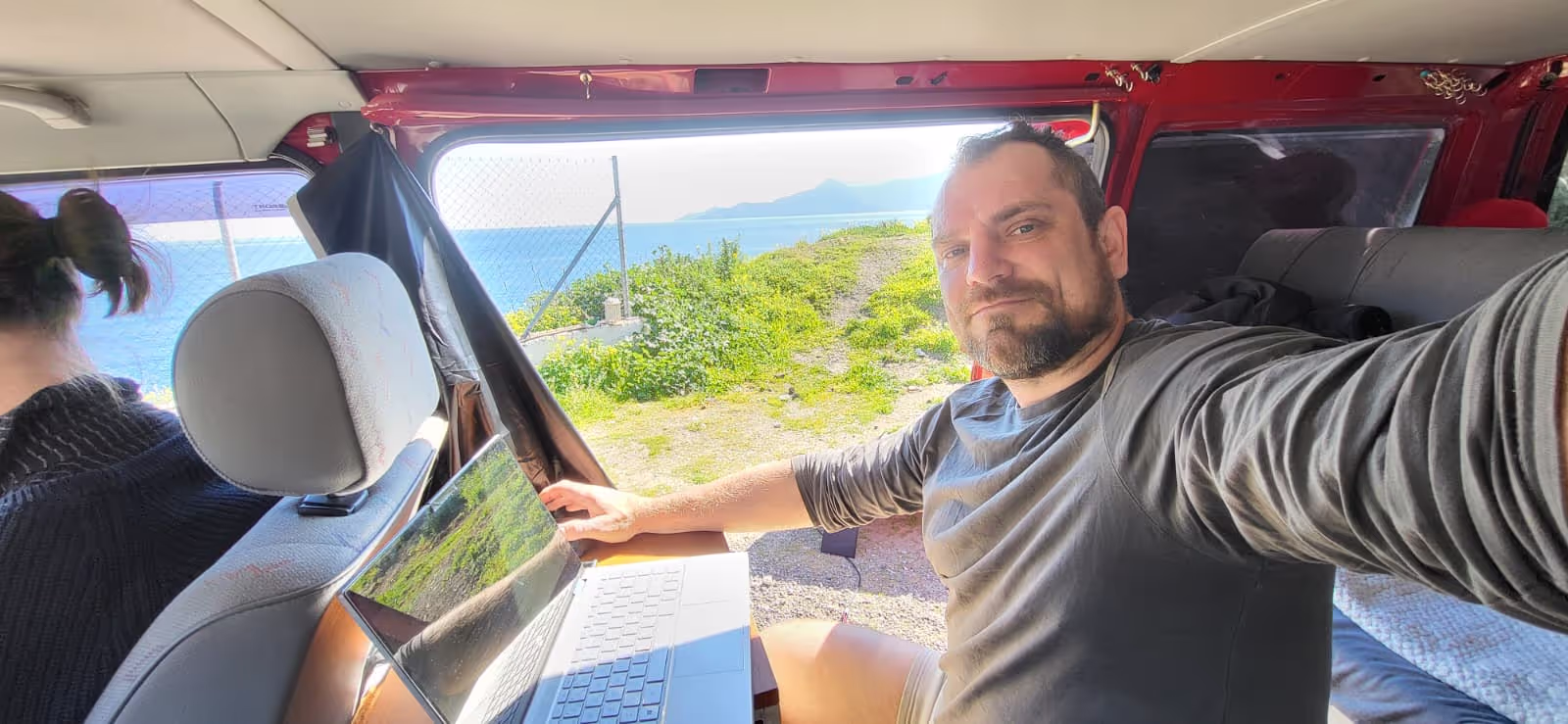 Konrad working from his laptop in the VW T4 in Greece
