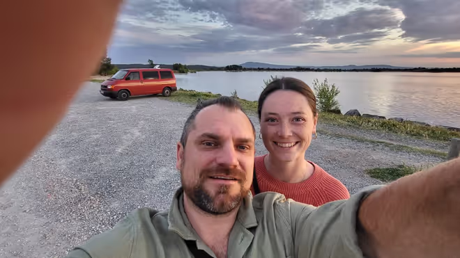 Konrad and Caro by a lake in France, with their VW T4 behind them Konrad and Caro by a lake in France, with their VW T4 behind them