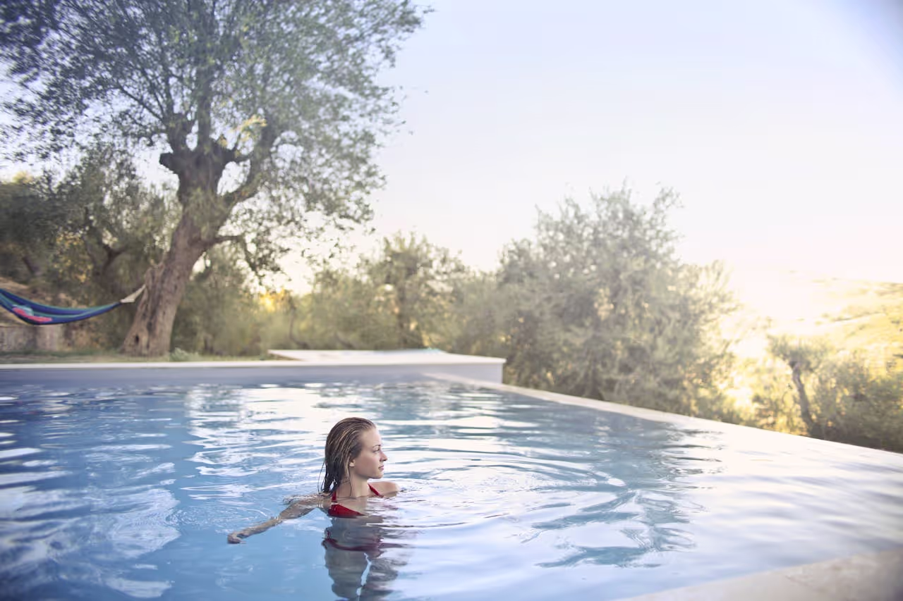 An outdoor swimming pool with a woman swimming in it An outdoor swimming pool with a woman swimming in it