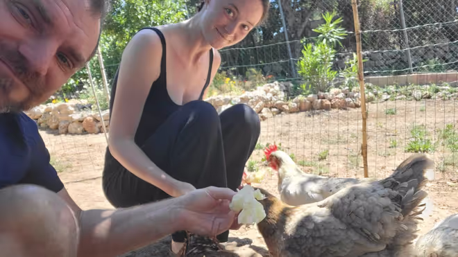 Konrad and Caro feeding chickens during their house sit in Portugal Konrad and Caro feeding chickens during their house sit in Portugal