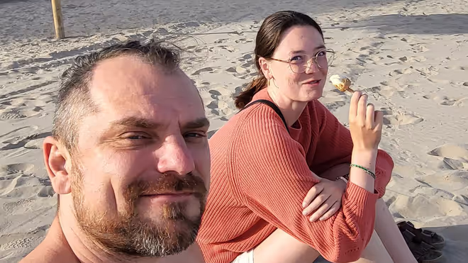 Konrad and Caro sitting on a beach in Portugal Konrad and Caro sitting on a beach in Portugal