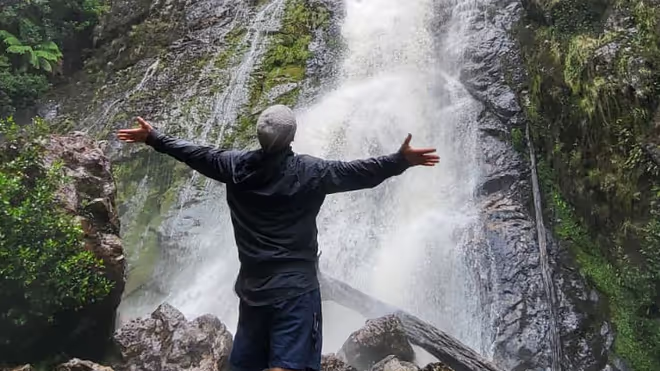 Konrad standing in front of a waterfall