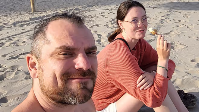 Konrad and Caro sitting on a beach in Spain Konrad and Caro sitting on a beach in Spain