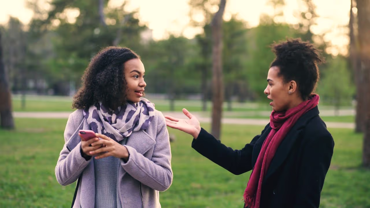 two women talking to each other.