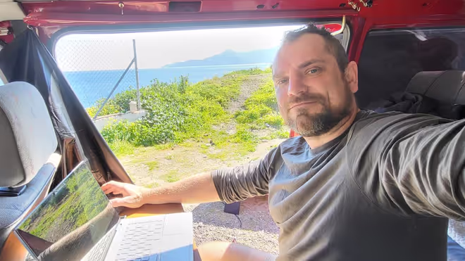 Konrad working on the laptop from the van