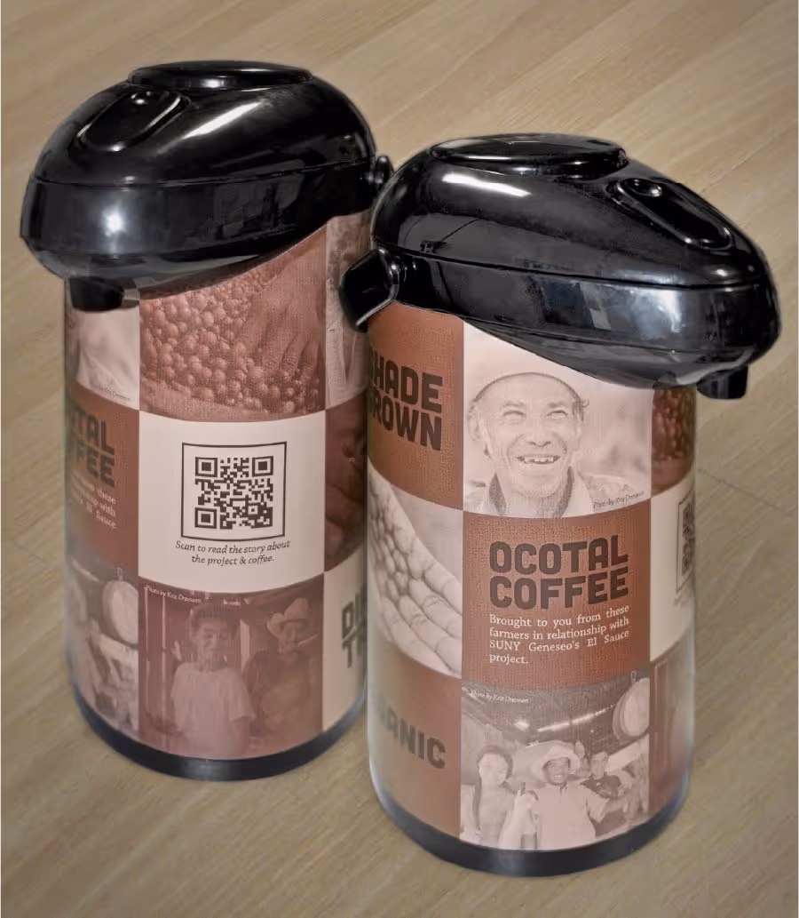 Two coffee airpots, black on top, with brown and white labels featuring images of coffee beans, smiling farmers, and text advertising 'Ocotal Coffee' and 'Shade Grown', along with a QR code to read the project story.