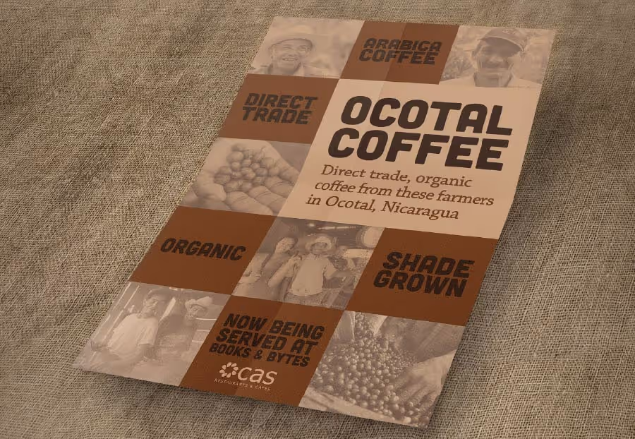 An informational flyer for Ocotal Coffee, displayed diagonally on a textured beige surface. The flyer has a grid design with brown and light beige sections. The main title, 'OCOTAL COFFEE,' is in bold dark text on a light beige background. Below it reads, 'Direct trade, organic coffee from these farmers in Ocotal, Nicaragua.' Brown sections highlight key features: 'ARABICA COFFEE,' 'DIRECT TRADE,' 'ORGANIC,' and 'SHADE GROWN.' Sepia-toned images within the grid show coffee farmers, hands holding coffee beans, and piles of raw coffee beans. At the bottom, it states 'NOW BEING SERVED AT BOOKS & BYTES' with a 'CAS RESTAURANTS & CAFES' logo.