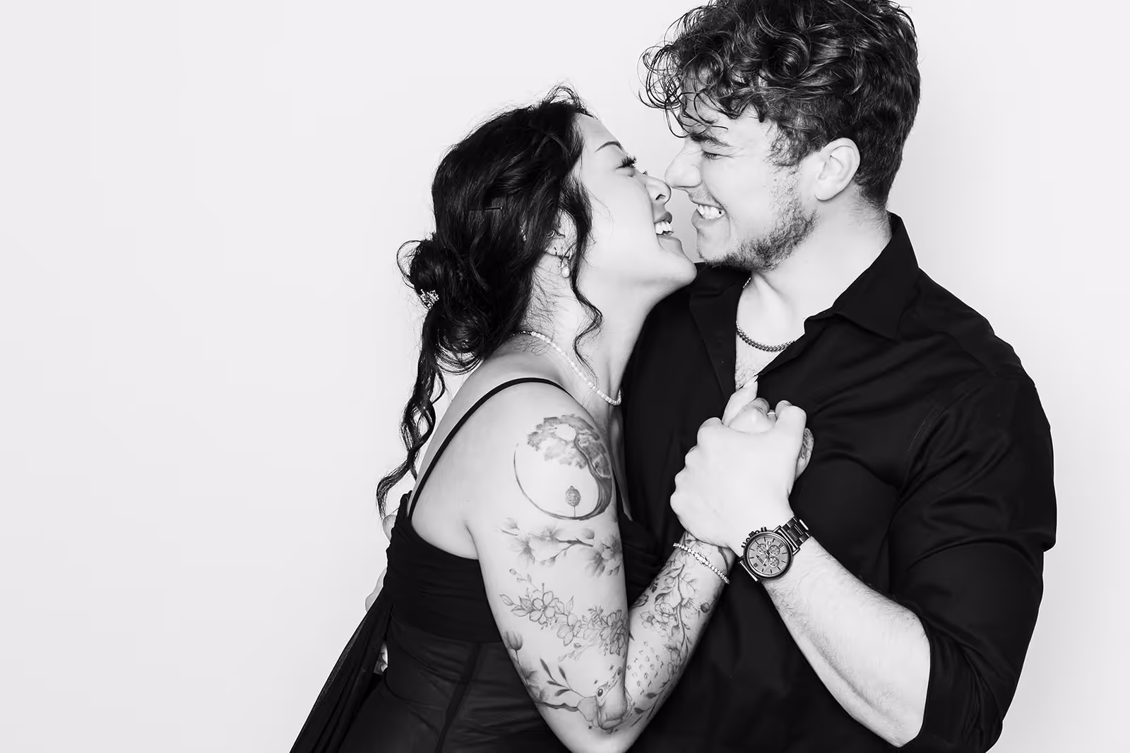 A female leaning on to her husband while he holds her hand on his chest in a black and white photo