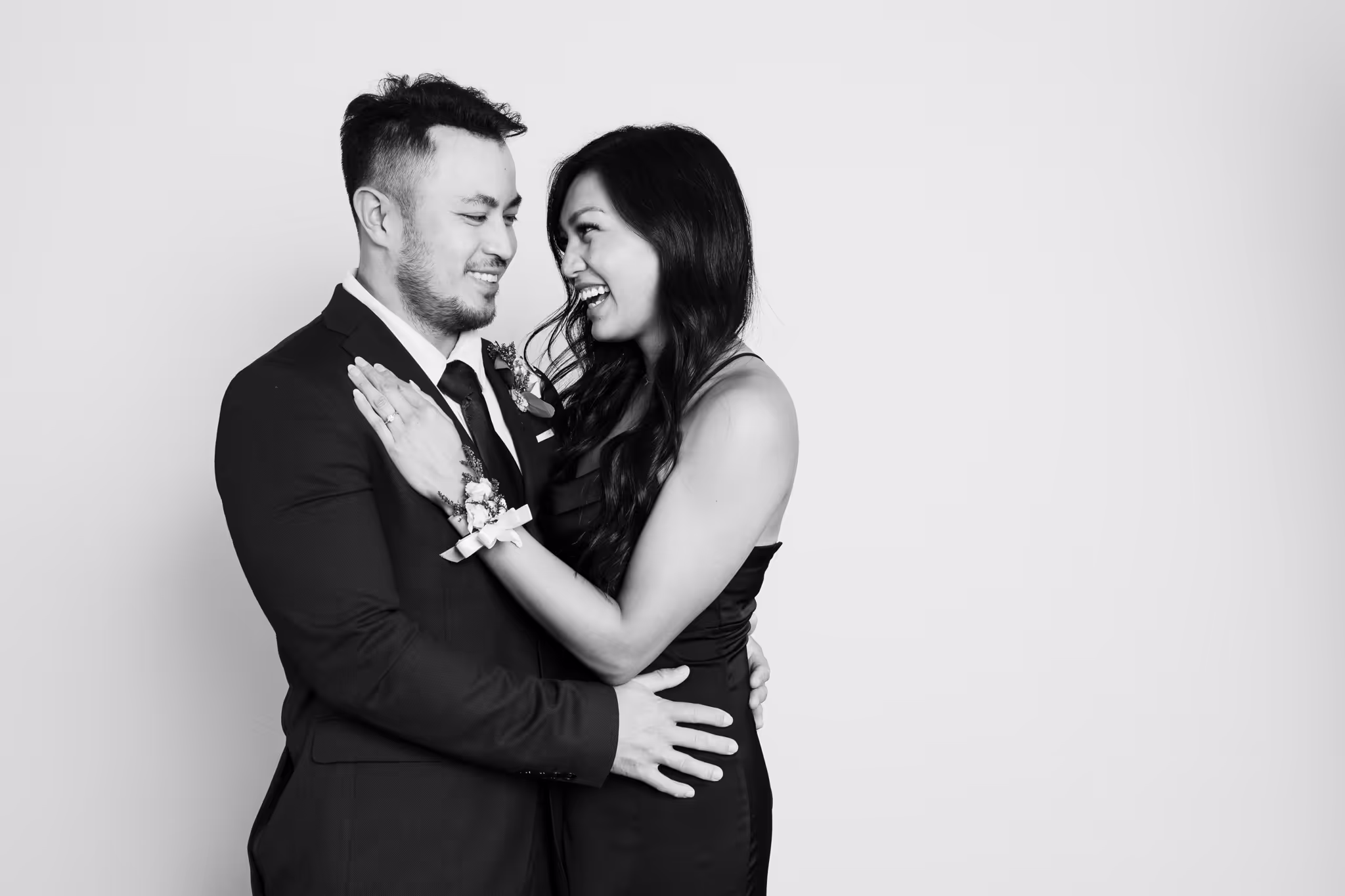 Asian couple leaning into each other in a black and white photo